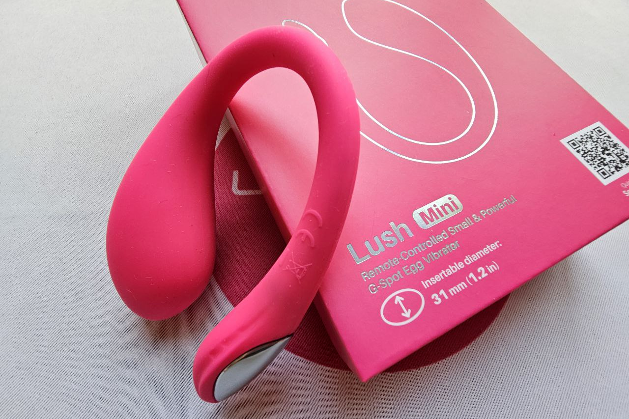 The image features the Lovense Lush Mini, a compact and discreet G-spot egg vibrator, prominently displayed against a softly blurred background. Its sleek design includes a vibrant LED light tail, highlighting its modern features and suitability for intimate moments, while the overall aesthetic emphasizes its role as a fun and pleasurable Lovense toy.